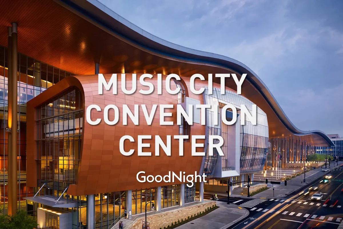 This image features the iconic, vibrant exterior of the Music City Center, with its distinctive curved roof, bold orange facade, and expansive glass windows. The scene conveys an atmosphere of energy and innovation, ideal for conferences, exhibitions, or business-related events.